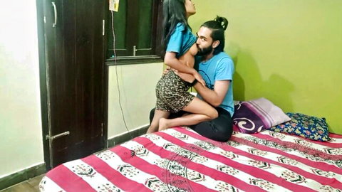 Sexy Indian woman in short skirt straddles bearded man's lap as he kisses her neck passionately on bed