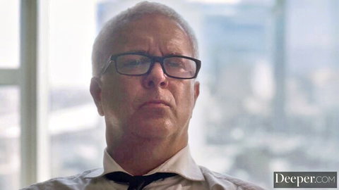 Mature man with glasses in white shirt and black tie stares seriously at camera
