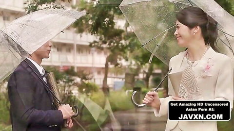 Japanese couple in suits and dress share flirty gaze under clear umbrellas in rainy JAV romance