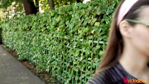 Hot teen girl in glasses and pink headband teasing outdoors
