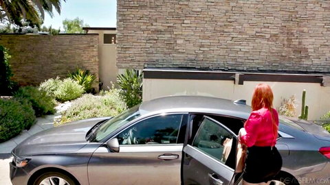 Lauren Phillips in pink blouse and black skirt by car, redhead MILF tease