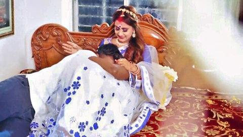 Indian housewife in white saree passionately hugs dark-skinned husband on ornate bed