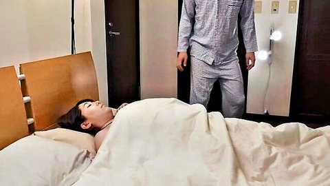 Sakura Minami lying asleep in bed, man in pajamas watching her