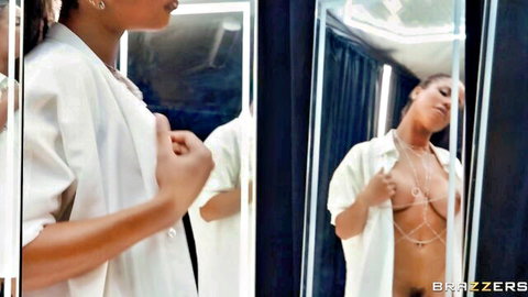 Kira Noir teasing in open white blazer and body chain, mirror view