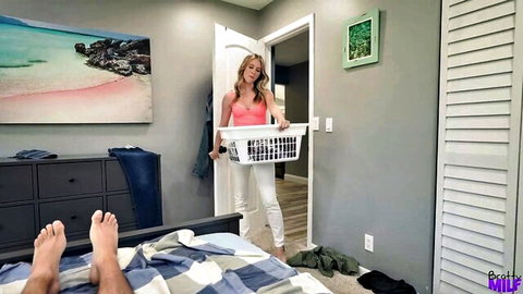 Anya Olsen as insatiable stepmom holding laundry basket near bed