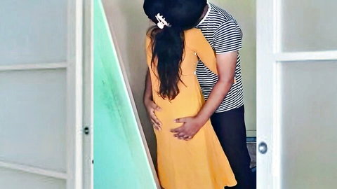 Sexy Indian woman in yellow dress hugged intimately from behind by man groping her hips