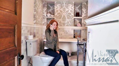 Miss Missa X redhead on phone in bathroom, casual jeans look