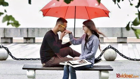 Intimate Asian couple under red umbrella on rainy bench, softcore tease