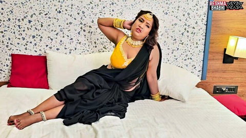 Seductive Indian MILF in black saree yellow blouse teasing massive cleavage big natural tits on bed