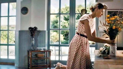 Fanta Sie in pin-up polka dot dress posing with flowers in country style