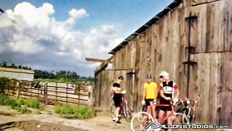 Three athletic cyclist studs in gear by barn, gearing up for raw gay spitroast threesome