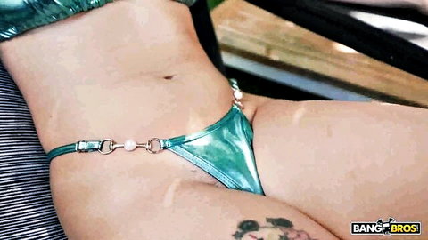Asteria Jade in shiny green thong, teasing close-up on slim body