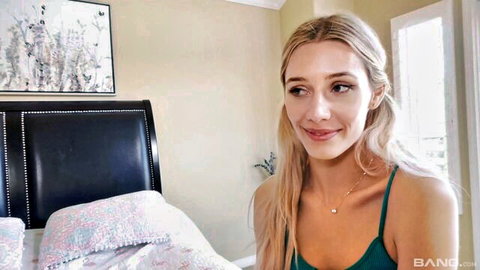 Emily Jade blonde beauty smiling seductively in green camisole on bed