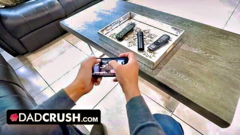 POV closeup of man's hand holding smartphone on wooden coffee table with remotes