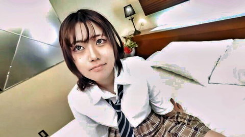 Asian schoolgirl in uniform on bed, seductive gaze