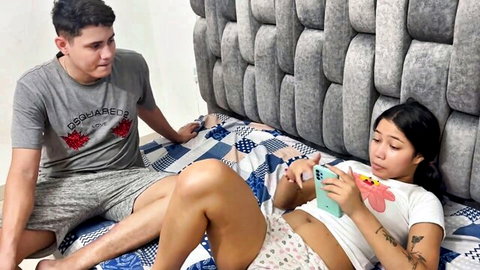 Shy Asian stepsis in crop top and shorts relaxes on bed with stepbro gazing lustfully