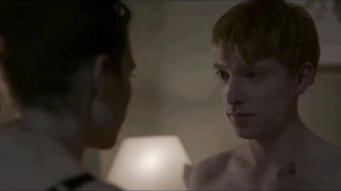 Shirtless red-haired man in intimate close-up with dark-haired partner, romantic nude scene