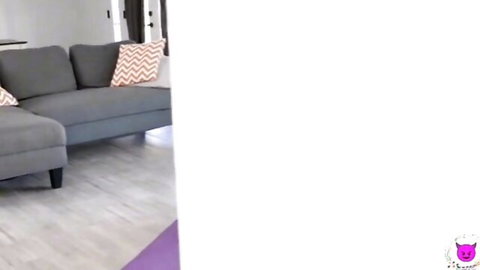 Empty modern living room with gray L-shaped sofa orange pillows and purple yoga mat