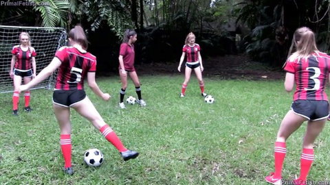 Skinny blonde soccer girls in tight shorts and jerseys kicking balls on grassy field
