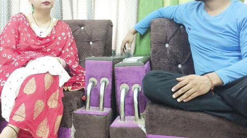 Hot South Asian Indian babe in red salwar kameez sitting next to guy in pedicure salon chairs feet up