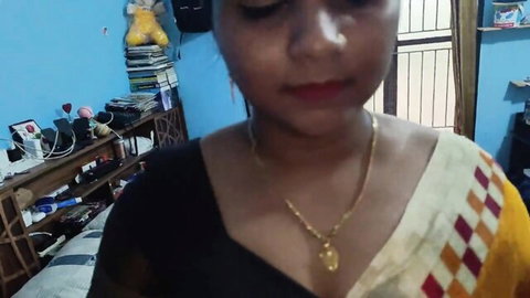 Sexy Indian woman in saree blouse with deep cleavage and gold necklace smiling seductively