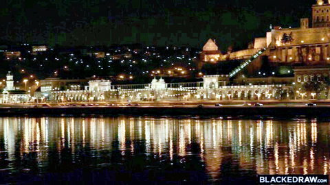 Stunning night cityscape of illuminated bridge castle and river reflections with BlackedRaw watermark