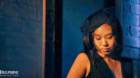 Seductive Asian woman in black veil and low-cut top against brick wall
