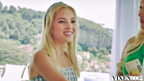 Flawless blonde Bella smiling in checkered top, friend holds cash in Vixen scene