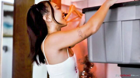 Kimmy Kimm in tight white tank top reaching up seductively