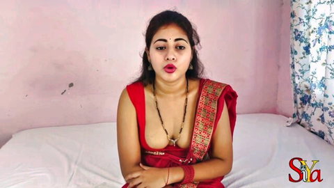 Sexy Indian Bhabhi in red saree with deep cleavage, smiling seductively