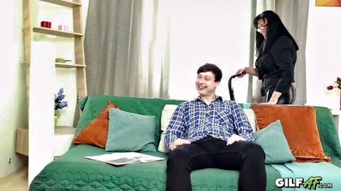Massive-breasted Asian GILF with glasses leashes smiling man on sofa