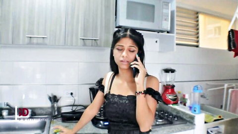Sexy brunette babe in revealing black lace top talking on phone in kitchen