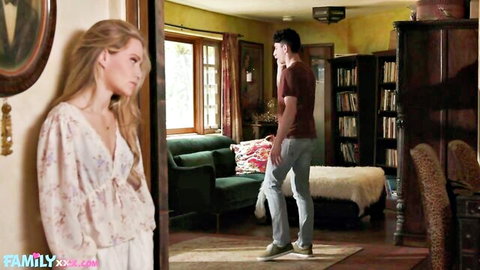 Blonde MILF in revealing white blouse glances away as guy stands in vintage living room