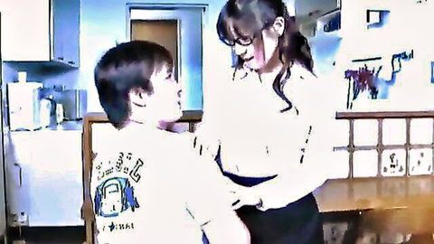 Mature Asian mom with glasses chats with young son in kitchen