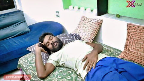 Indian bearded man in t-shirt and shorts lying on bed, hand near crotch, from patient's patient sex scene