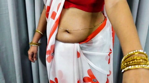 Curvy Indian woman in white saree and red blouse exposes soft belly navel and gold waist chain