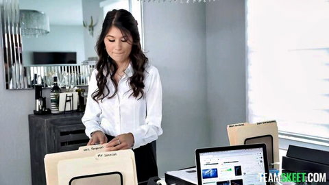 Slim Asian office girl in tight white blouse and skirt holds folders teasingly