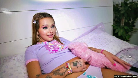 Cute tattooed Mia Kay in playful purple outfit hugging teddy bear on bed