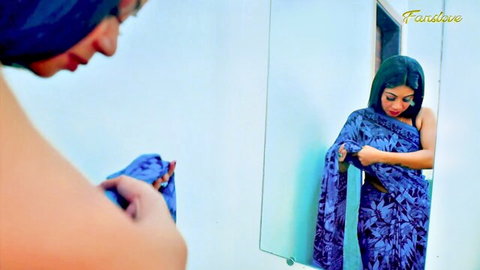 Sexy Indian woman in blue saree adjusting pallu exposing bare back and sideboob in mirror
