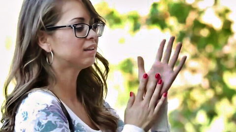 Brunette babe in glasses shows off red nailed hands outdoors teasing for handjob