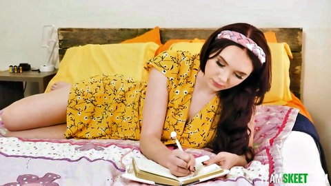 Scarlett Rosewood in yellow floral dress and stockings, writing seductively on bed