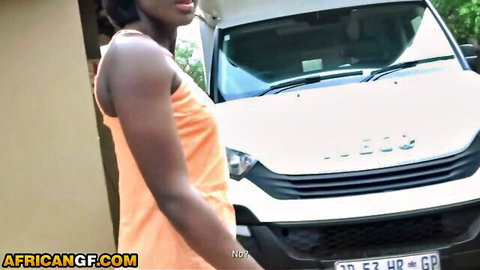 Sexy ebony babe in orange tank top posing seductively by white van outdoors