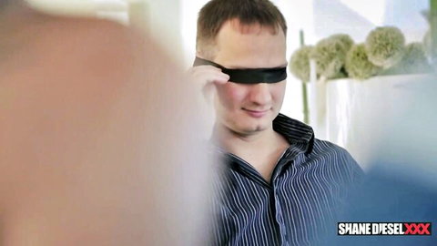 Shane Diesel blindfolded and smiling in interracial cuckold domination scene with Roxanne Rae