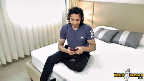 Indian man Nik in Adidas shirt on bed, steamy Airbnb host girl encounter Hindi uncut