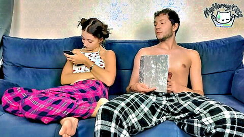 Step-sister on phone ignores step-brother hiding erection in pajamas on couch