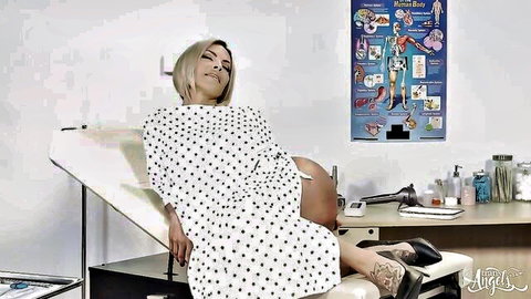 Blonde bombshell with huge tits exposes body in open polka-dot gown on medical exam table