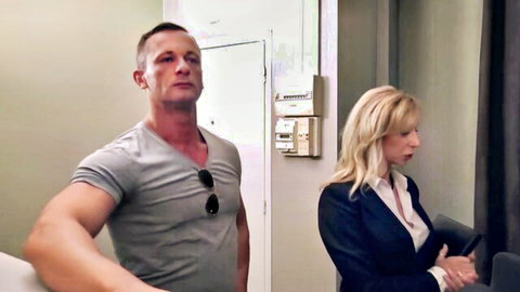 Muscular stud in tight tee flirts with busty blonde cougar MILF in suit by door