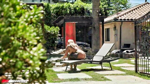 Curvy blonde Stephanie Love nude from behind on outdoor lounge chair
