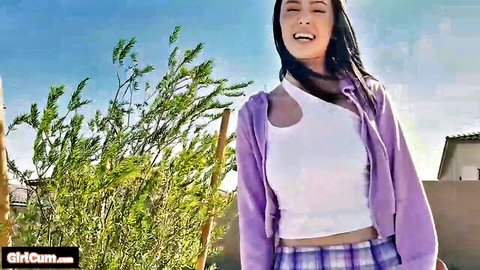 Mariana Flores smiling in sexy white crop top, purple cardigan and plaid skirt outdoors