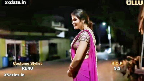 Desi Indian woman in pink saree smiling outdoors at night